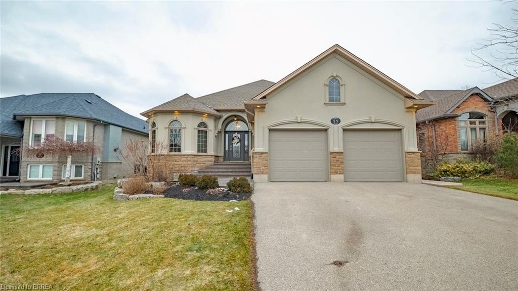 Custom-built bungalow with stone and stucco exterior, arched windows, landscaped front yard, and oversized double car garage at 35 Long Lane Paris Ontario